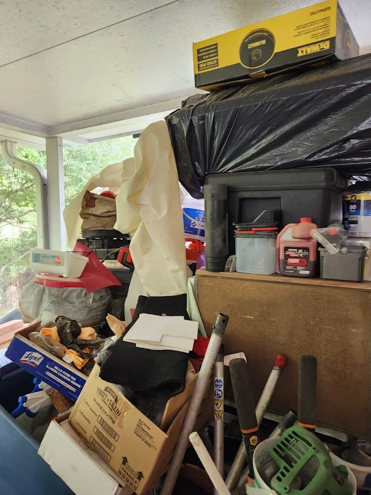 Before photo of a screened porch cluttered with tools and supplies