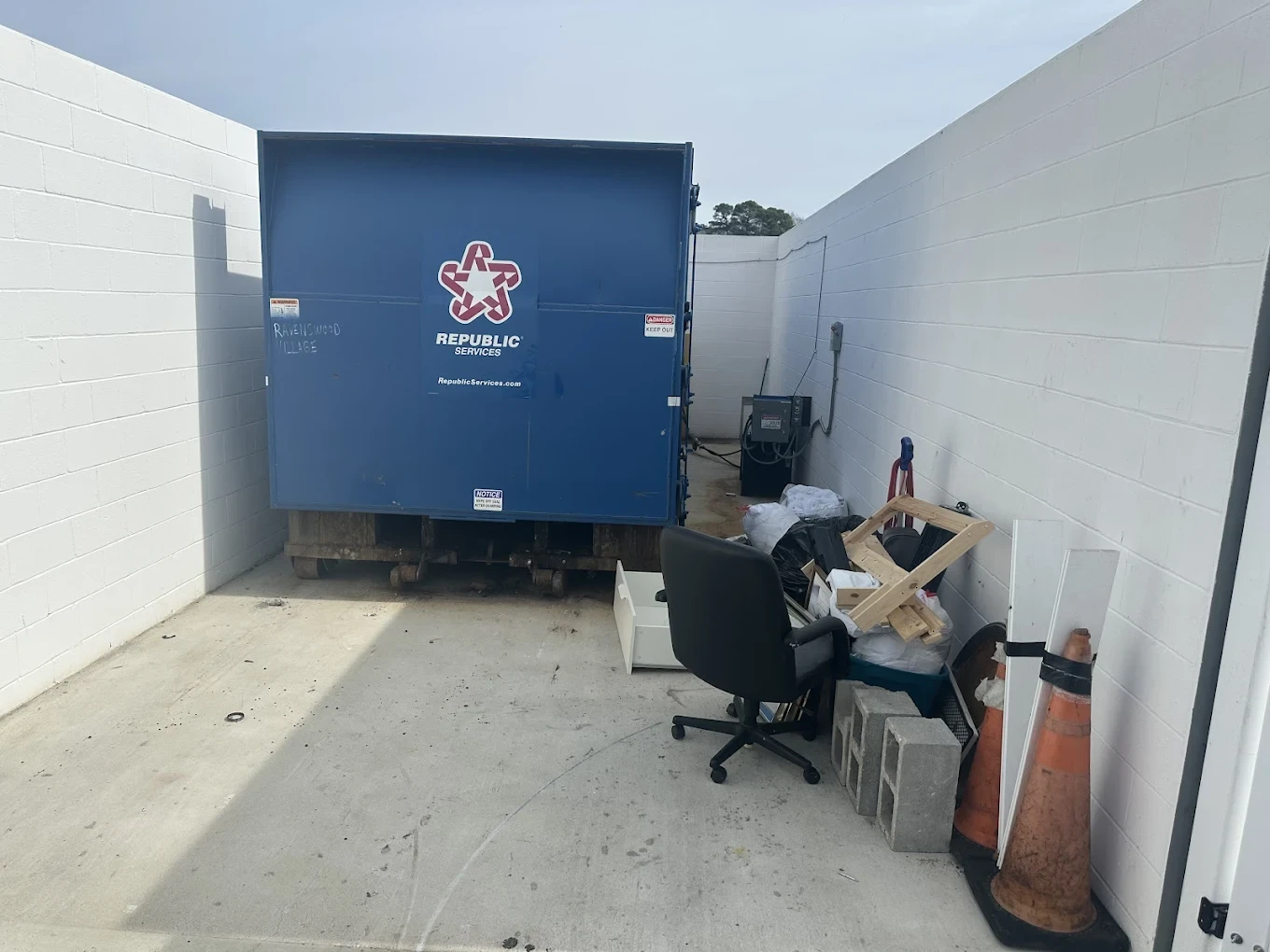 Dumpster enclosure at a Jacksonville apartment community piled with bulk items
