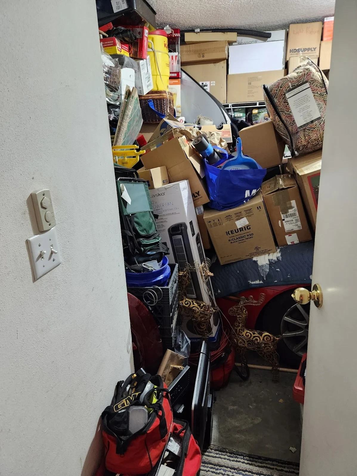 Closet packed floor to ceiling with boxes and belongings before a hoarder cleanup