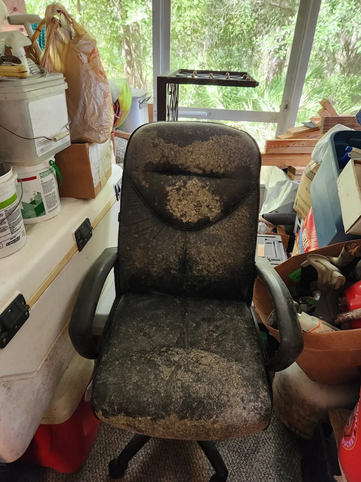 Old worn office chair among clutter ready for furniture removal in Jacksonville